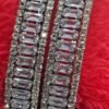 Silver-Plated Bangles Set featuring cubic zirconia and American diamonds, displayed on a vibrant red background for a striking contrast.