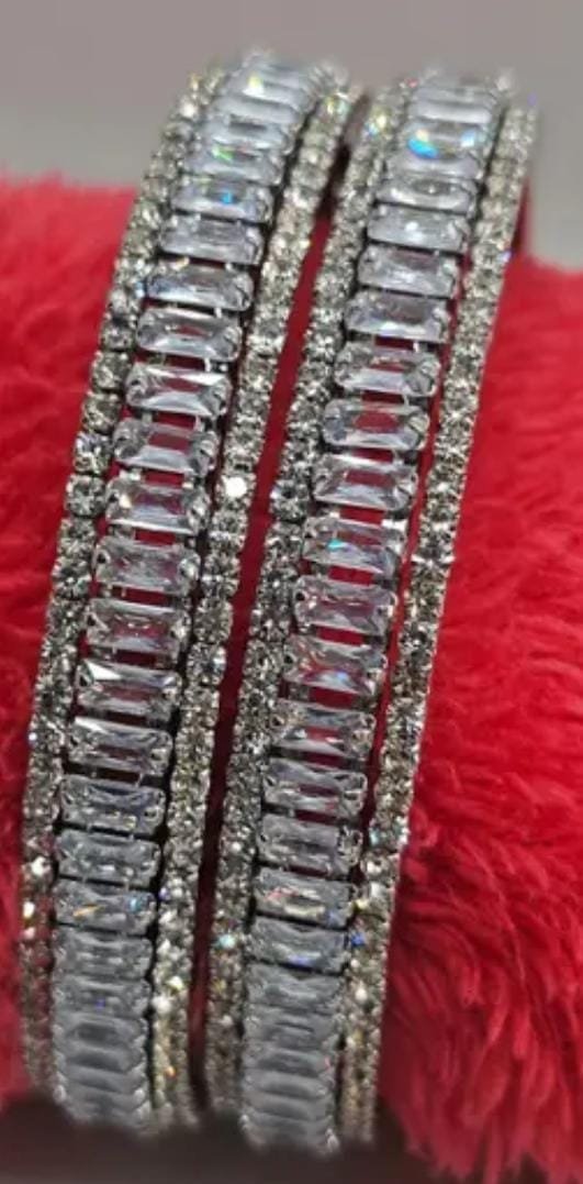Silver-Plated Bangles Set featuring cubic zirconia and American diamonds, displayed on a vibrant red background for a striking contrast.