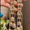 Gold-plated multi-layered jhumki earrings with Kundan stones, featuring an elegant long ethnic design. Ideal for weddings, festive occasions, and traditional wear.