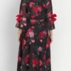 Back view of black maxi dress featuring pink roses, georgette fabric, fit and flare shape, and elegant flowy bell sleeves.