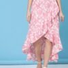 Close-up of the crepe fabric and elastic waistband of a women's floral asymmetric high-low skirt in pink.